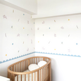 Wooden crib in a room with decorative wall stickers